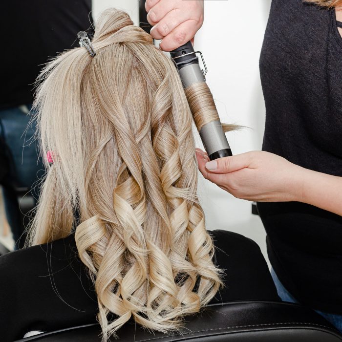 Set of hair dyeing process. Stylist making a hairdo with hair curler for blond woman after hair dyeing. Step 6 of 7